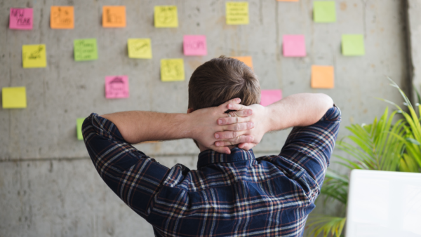 Homem olhando parede com post-it